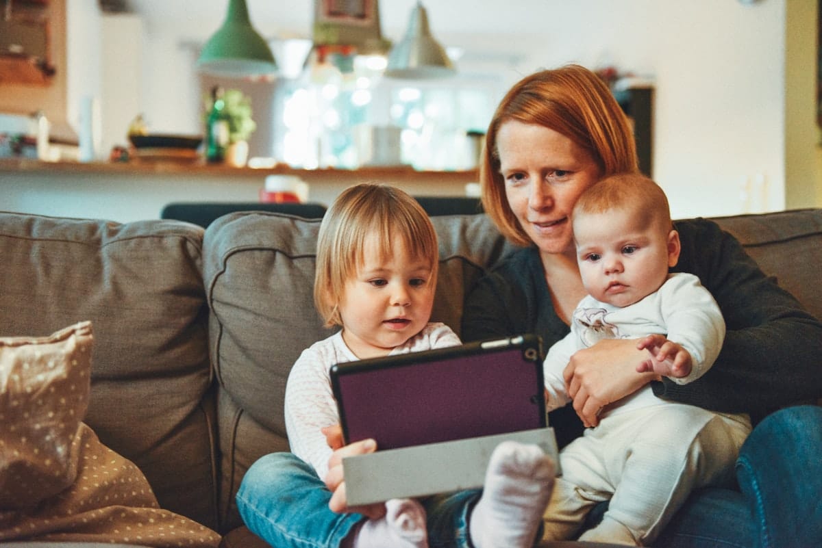 Eltern erledigen den Elterngeld-Antrag zu Hause am Tablet